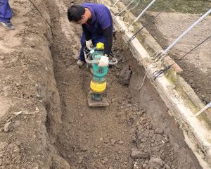 Workers installing gas pipeline in trench
