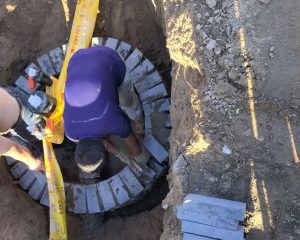 Worker connecting PE gas pipe in trench